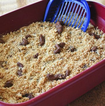 kitty litter cake with tootsie rolls and oreo crumbs in a litter pan with a scoop