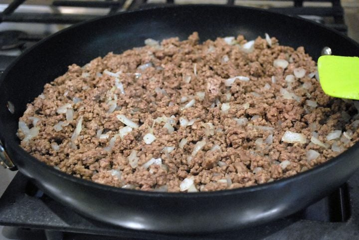 ground bison and onion cooking in a skillet