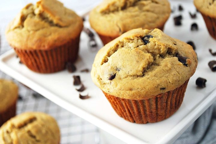 gluten-free banana chocolate chip muffins on a platter with chocolate shavings