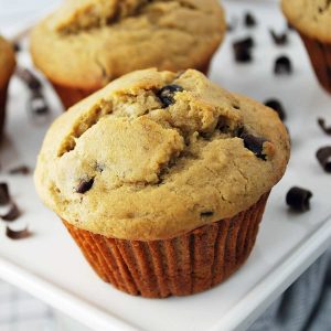 close up photo of a banana muffin with chocolate chips on a platter