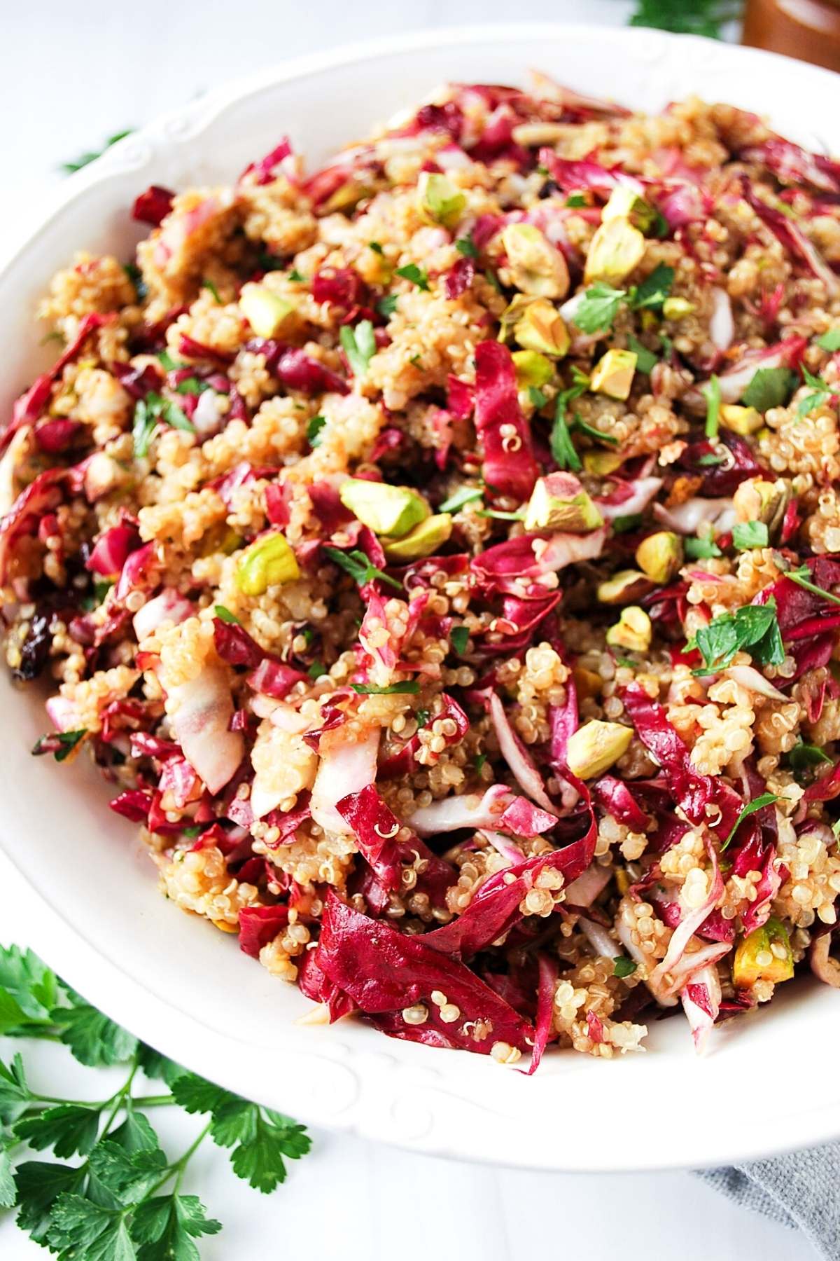 quinoa salad with cranberries and pistachios in a white serving bowl