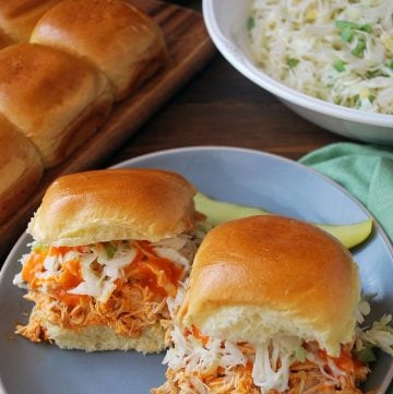 Buffalo chicken sliders on a plate with a pickle