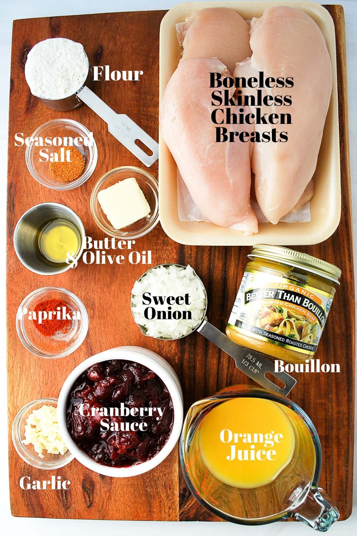 ingredients for orange cranberry chicken on a wood cutting board
