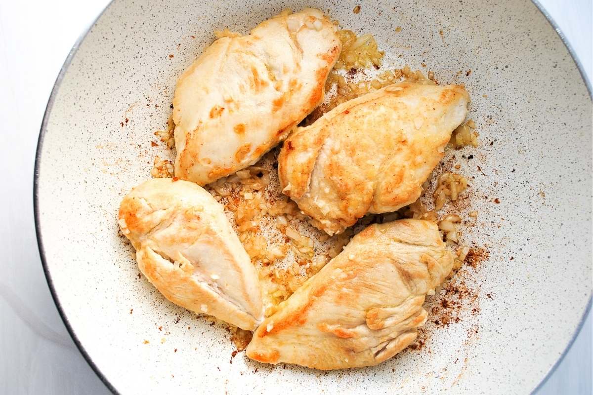 chicken, onion, and garlic sauteed in a skillet