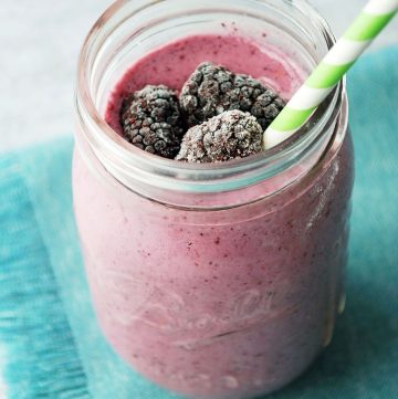 triple berry smoothie in a mason jar with straw