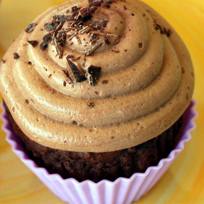 a chocolate pumpkin cupcake with chocolate shavings on top