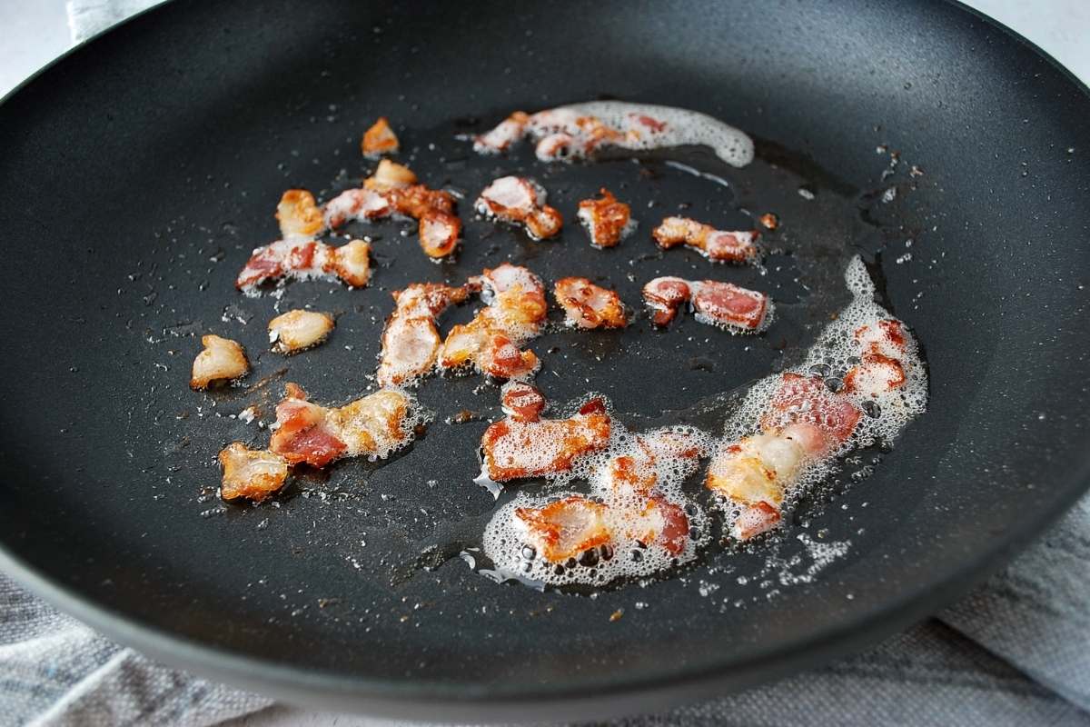 chopped bacon cooking in a skillet