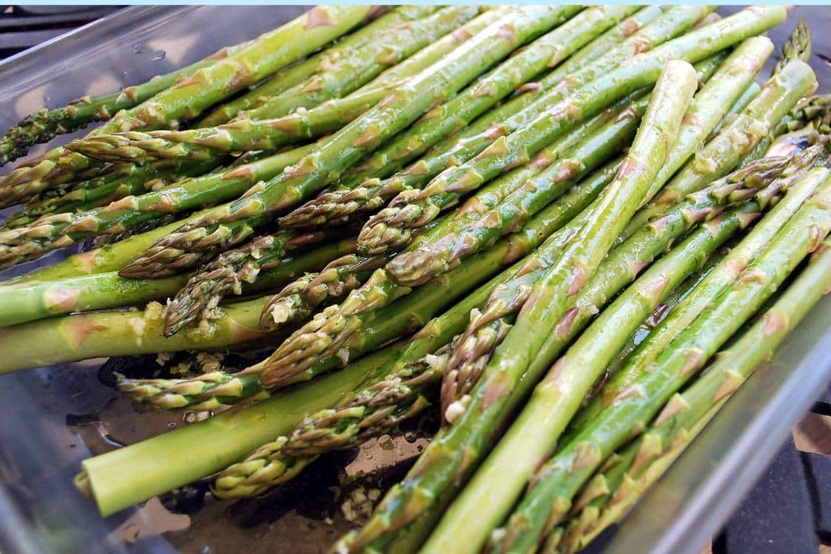 asparagus in a dish with marinade poured on top