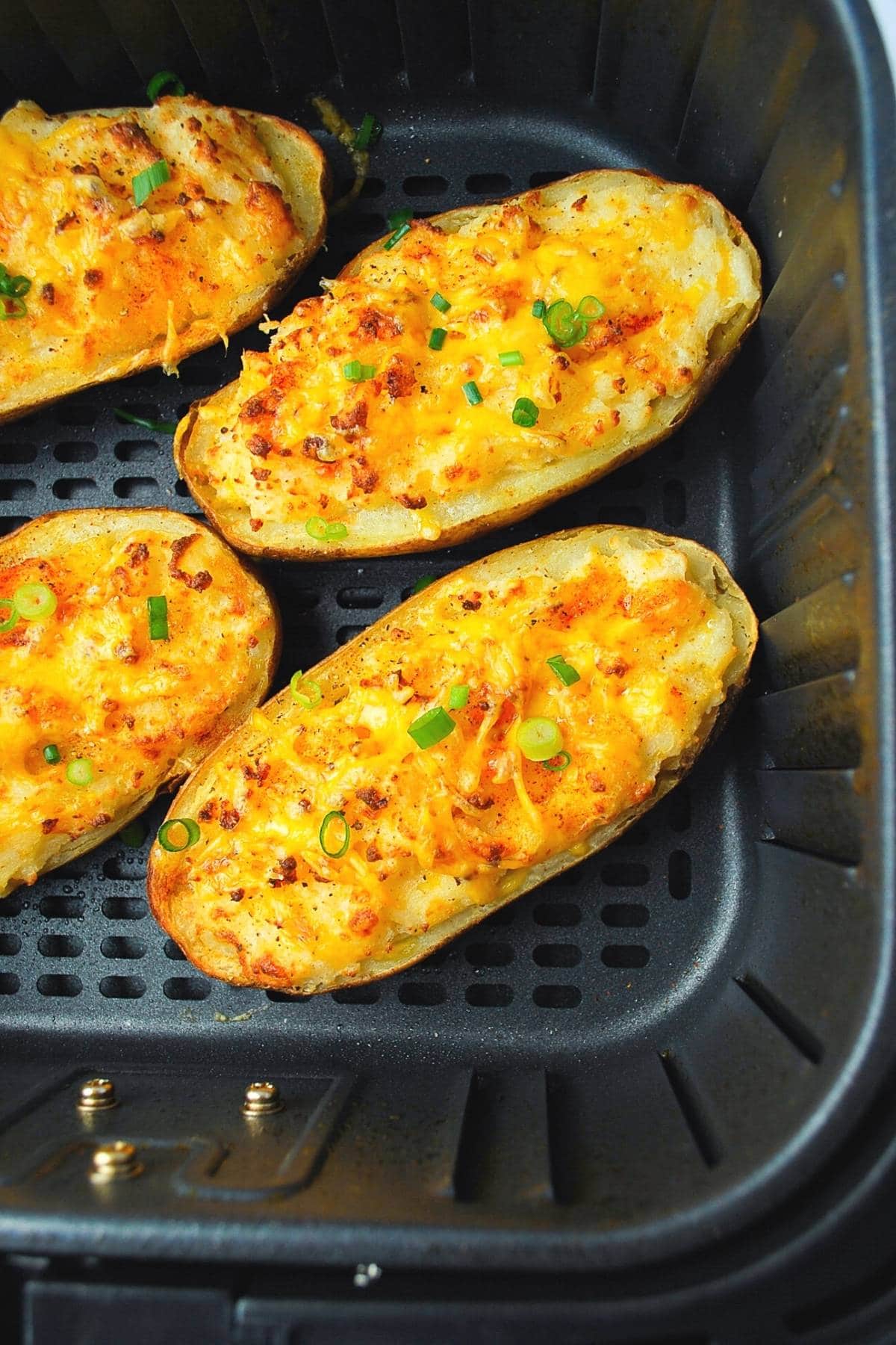 overhead photo of 4 twice baked potatoes in an air fryer basket