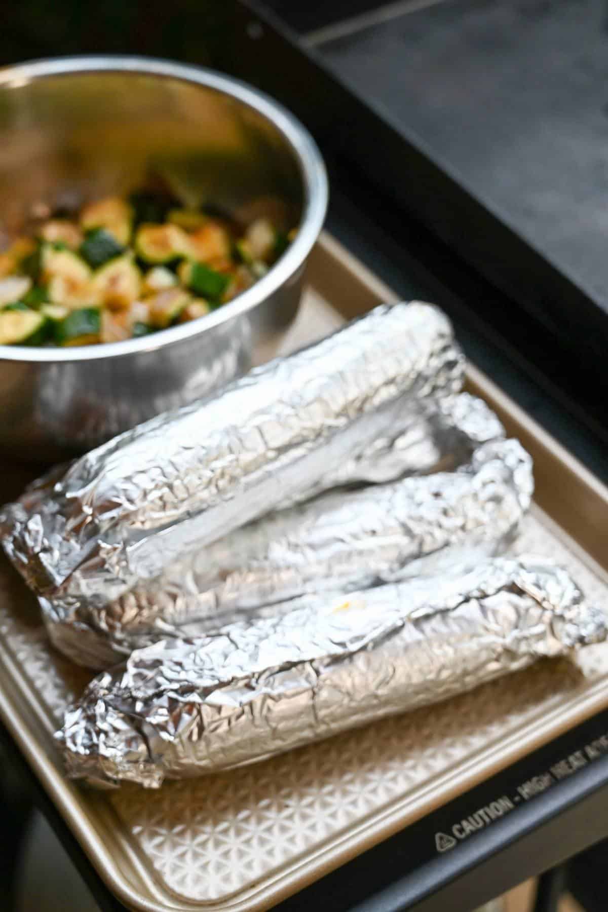corn rolled up in foil ready to cook
