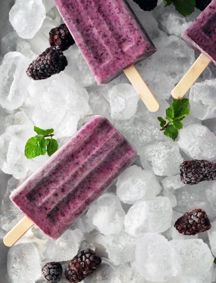 Greek yogurt popsicles made with berries on ice with blackberries and mint