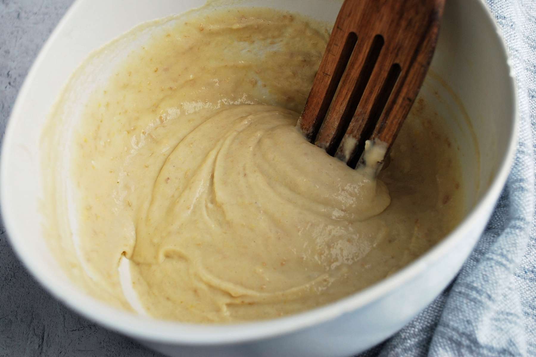 mixing pancake batter in a bowl with a wooden spoon