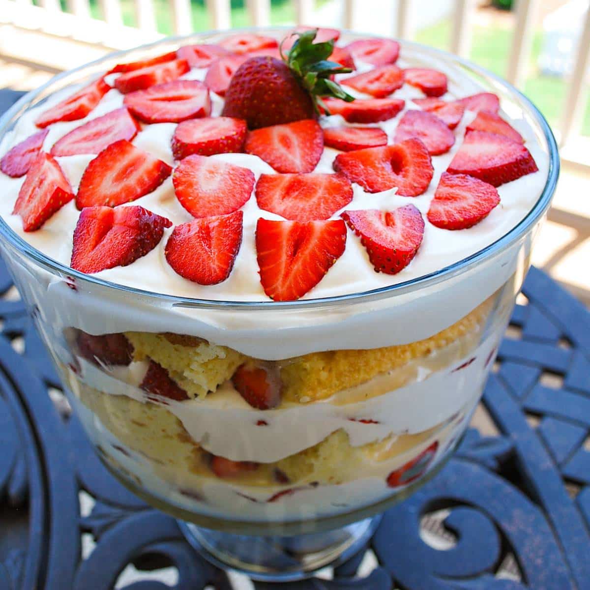 a tres leche trifle topped with sliced fresh strawberries on a table