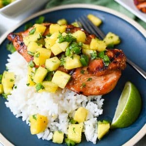 grilled chicken topped with fresh pineapple salsa with white rice and a lime wedge