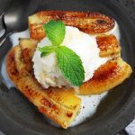 plate of caramelized bananas with ice cream and fresh mint