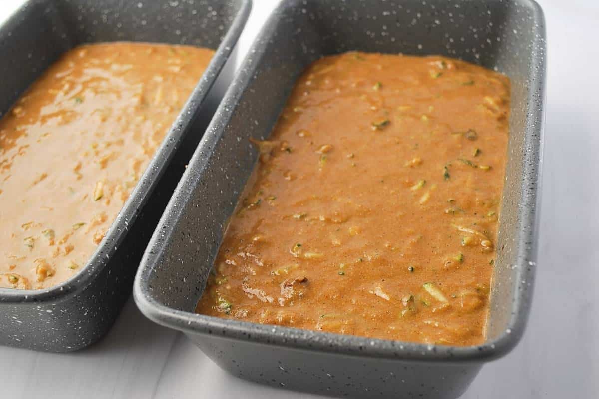 zucchini bread batter in two large loaf pans