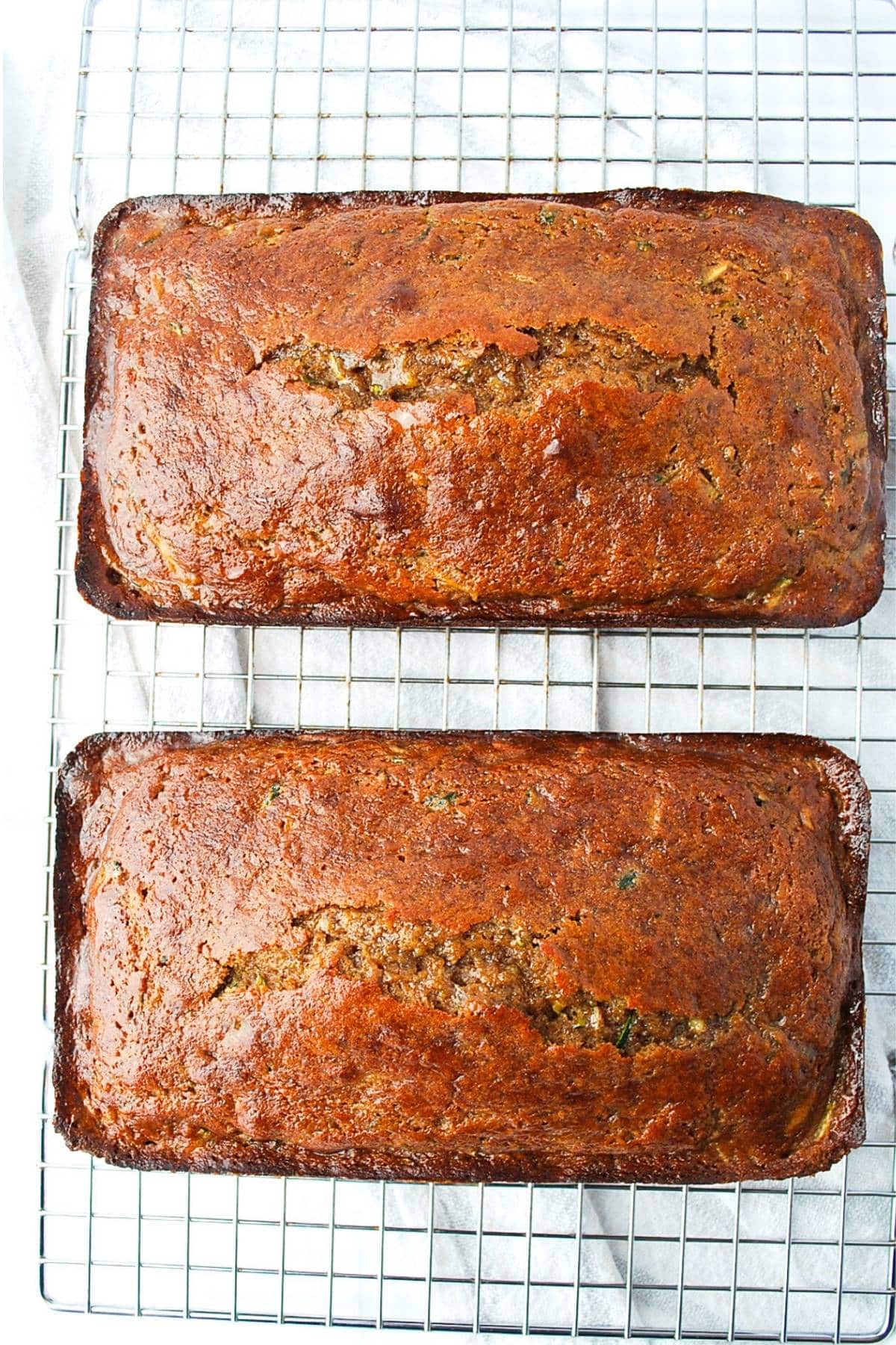 two freshly baked zucchini bread loaves on a cooling rack