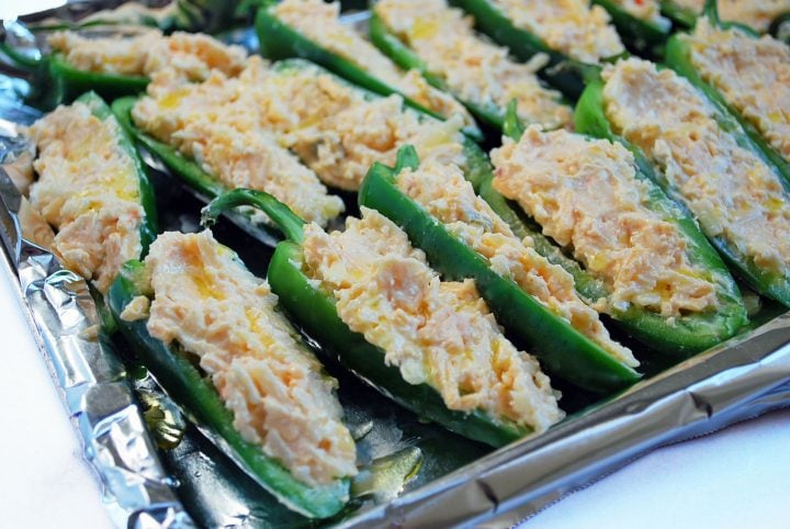 fresh jalapenos sliced in half and stuffed with cheese mixture ready to bake
