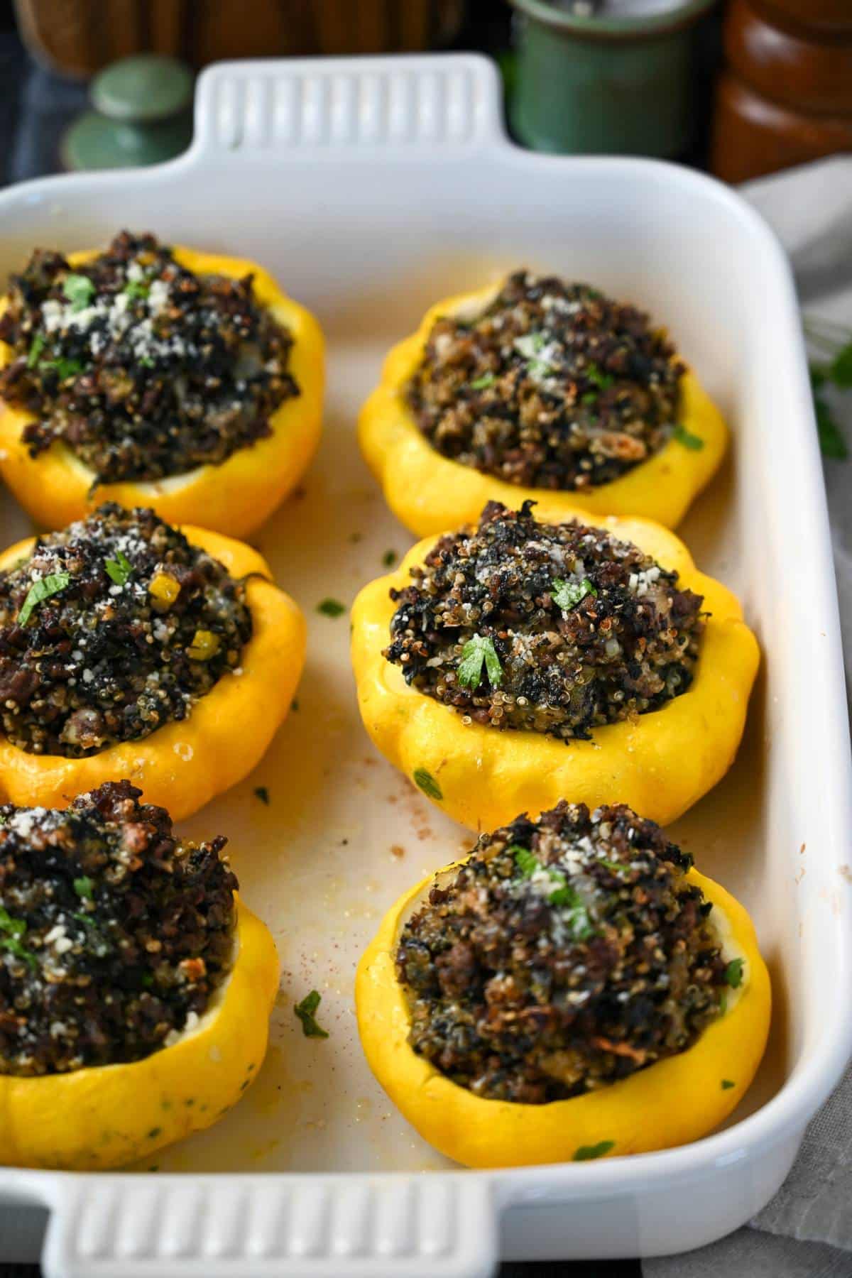 a pan of cooked stuffed patty pan squash in a white baking dish