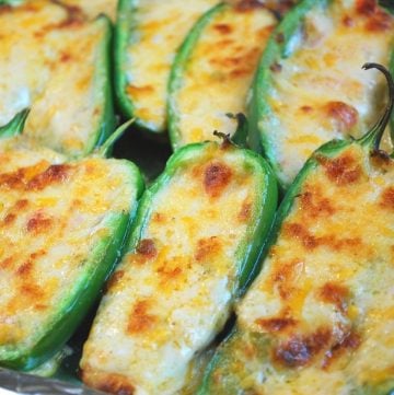 jalapeno peppers stuffed with melted cheese on a pan