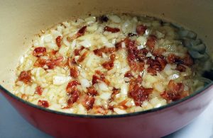 bacon and onions cooking in a dutch oven