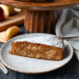 a slice of apple spice cake on a plate with a fork