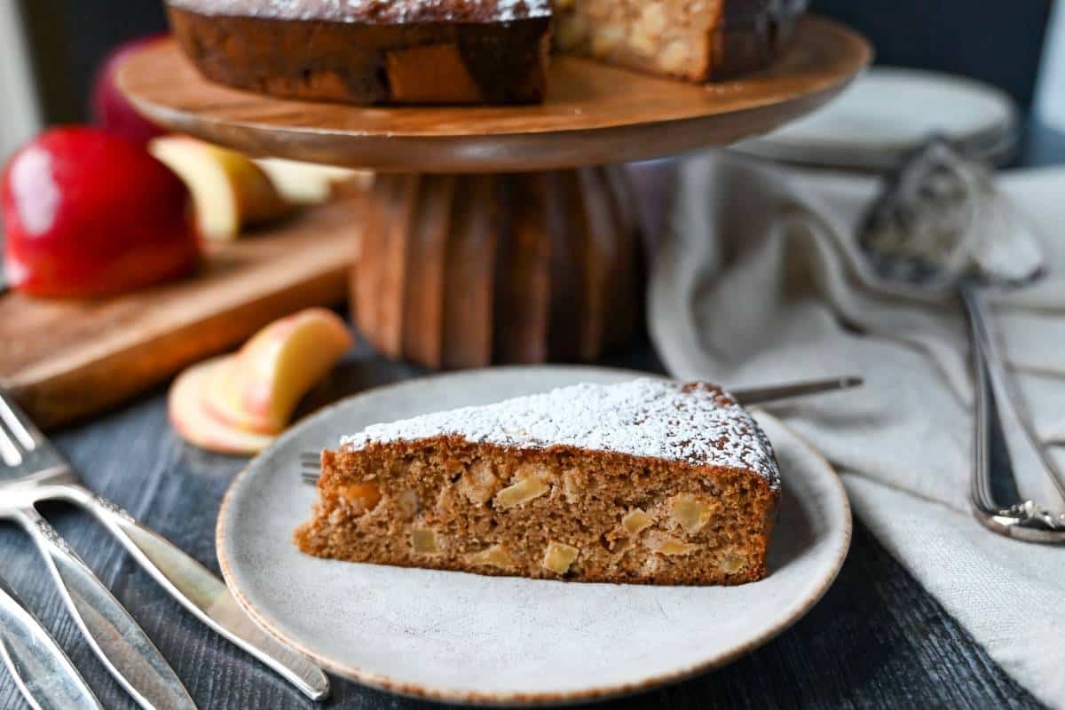 A slice of gluten free spice cake on a plate with a fork 