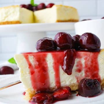 close up photo of a slice of cheesecake dripping with compote