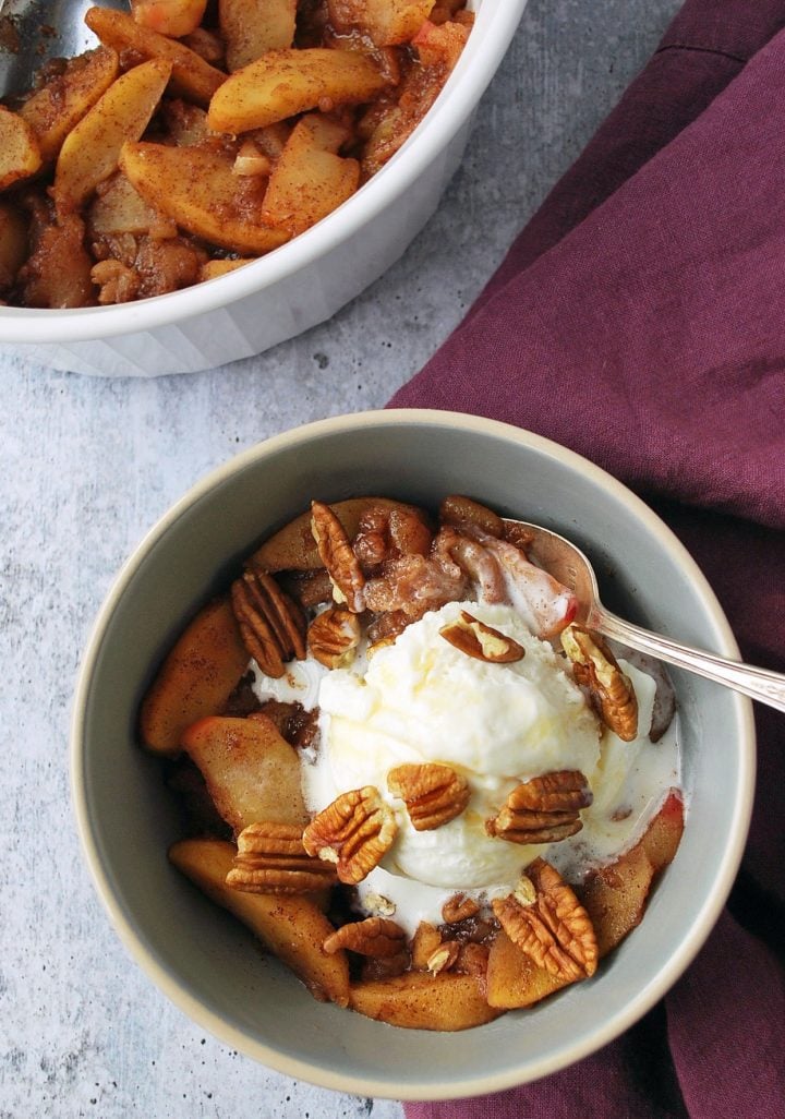 cooked baked apples in a pyrex dish with bowl of apples with nuts and ice cream