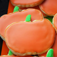 pumpkin shaped frosted sugar cookies on a platter