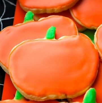 close up of pumpkin sugar cookies with a smooth royal icing on top