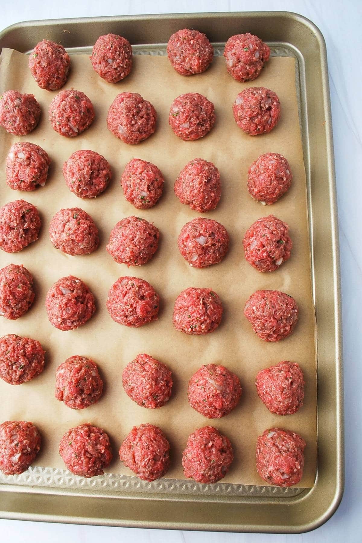 meatballs for meatball soup on a baking sheet lined with parchment paper
