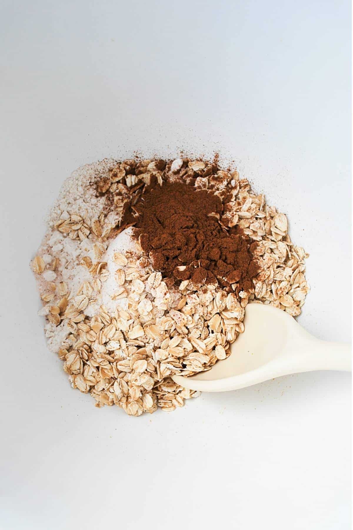 dry ingredients for oatmeal cranberry cookies in a white mixing bowl