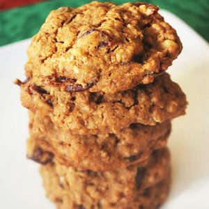 stack of oatmeal cookies on a white plate on top of a green napkin