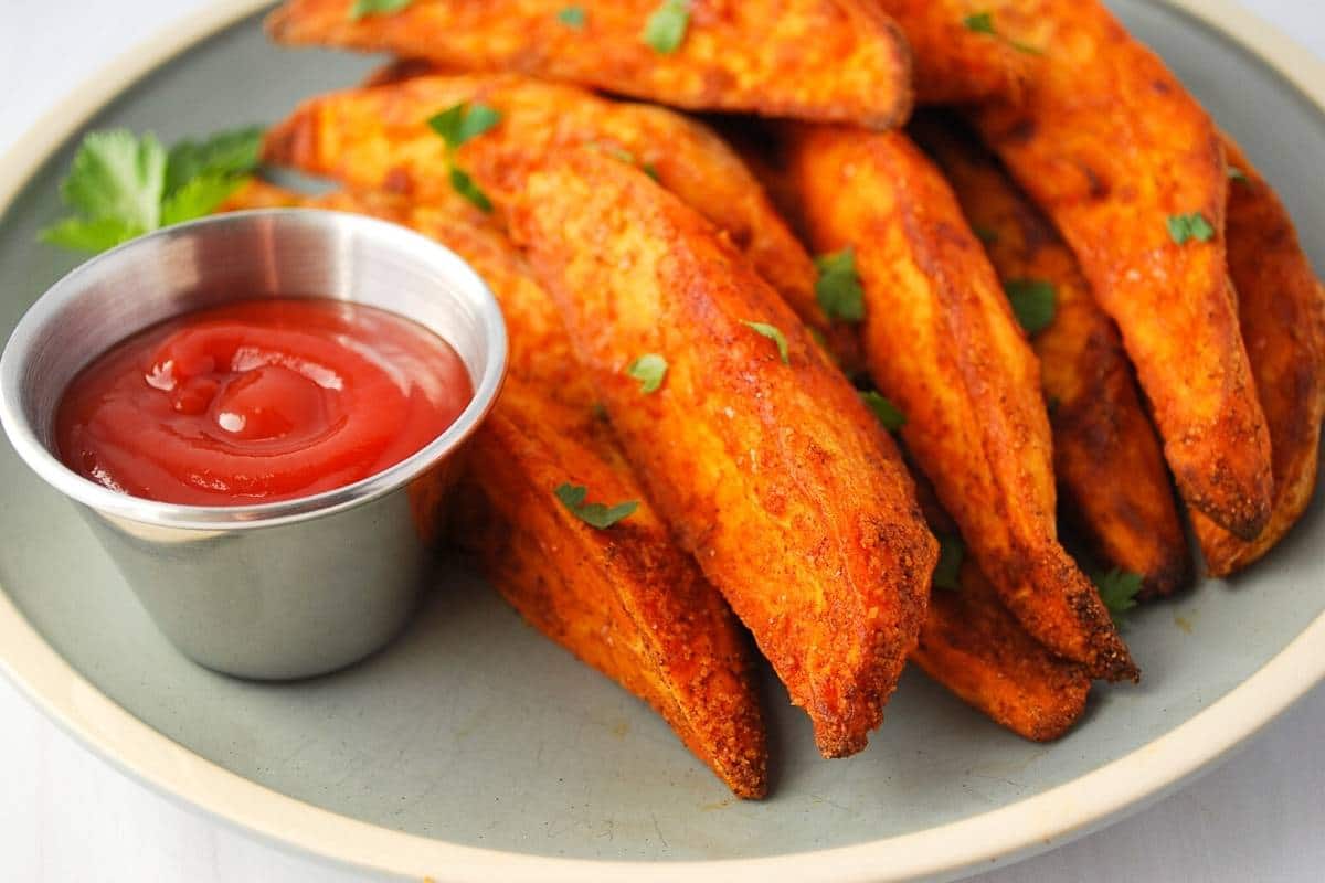 air fryer sweet potato wedges on a plate with ketchup