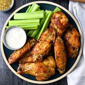 overhead photo of a plate of lemon pepper chicken wings with ranch and celery