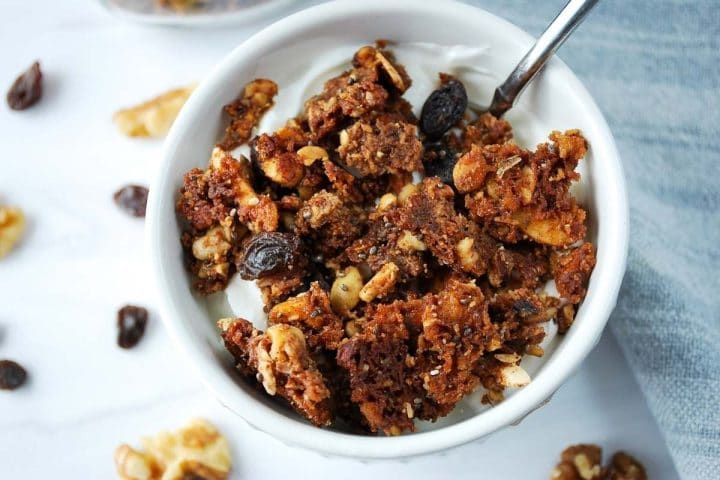 low-carb granola on top of greek yogurt in a bowl with a spoon