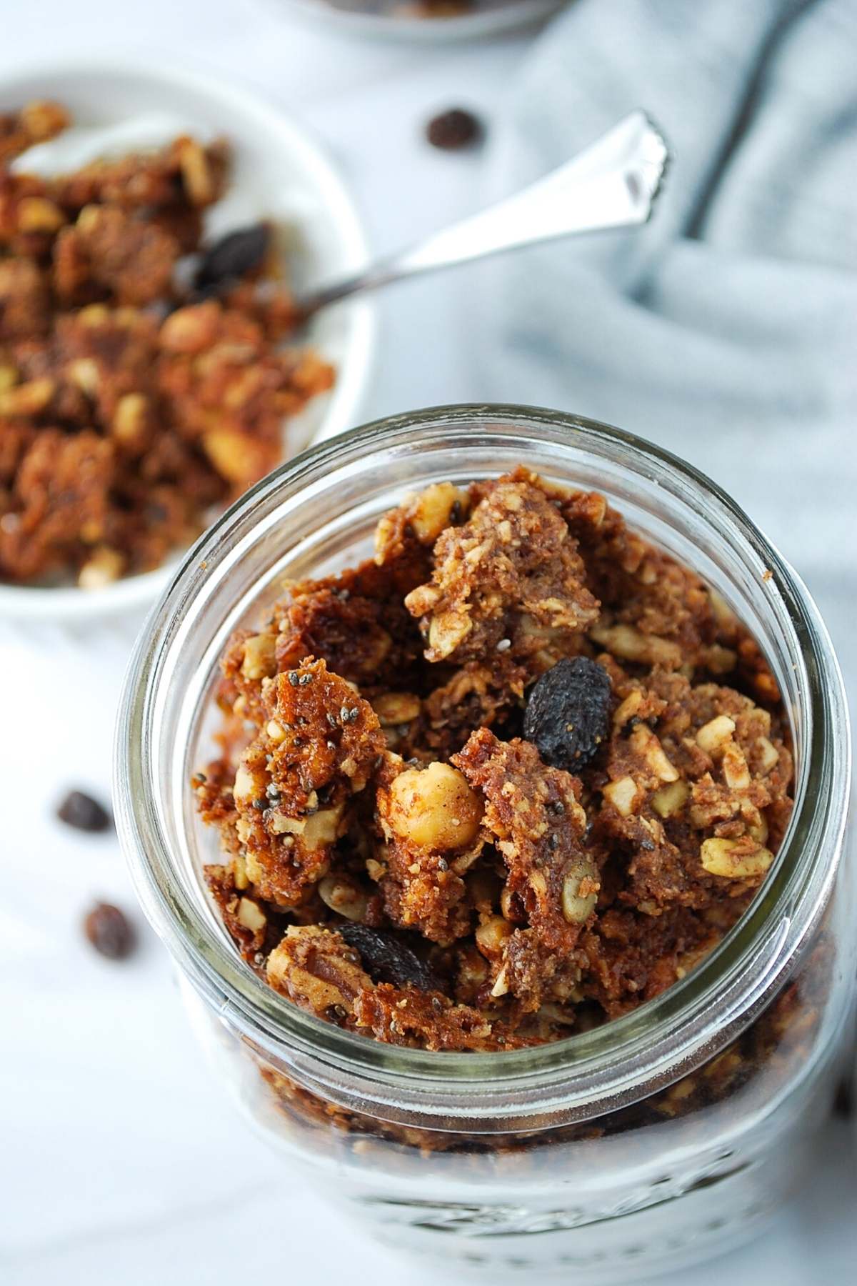 overhead photo of low carb granola in a mason jar with bowl of granola behind it