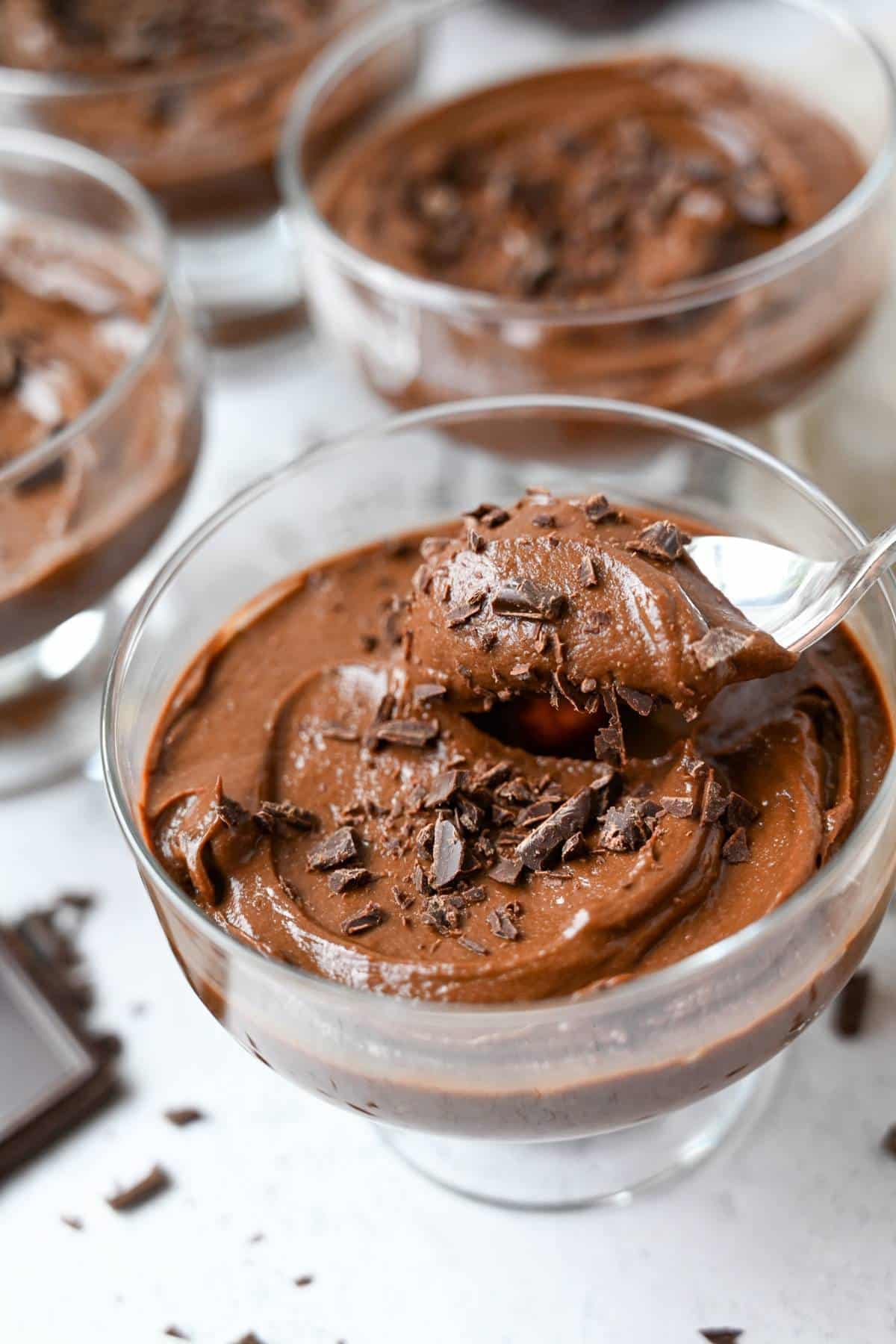 photo of clear dessert dishes with chocolate pudding with dark chocolate shavings