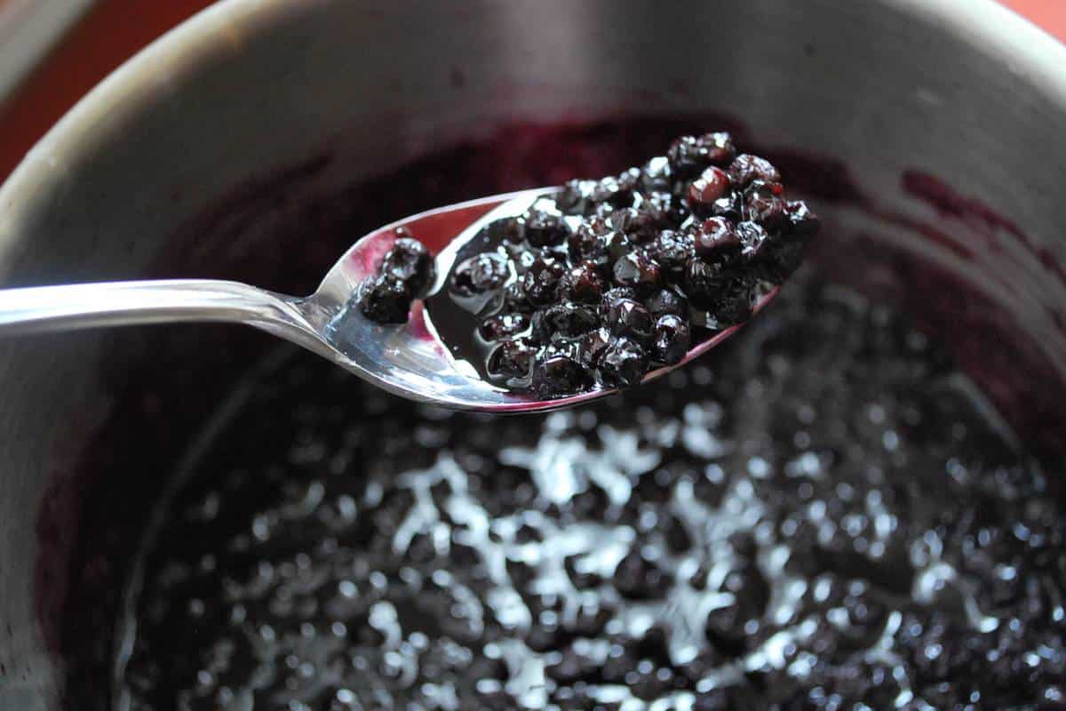 a spoonful of blueberry lemon compote over a sauce pan