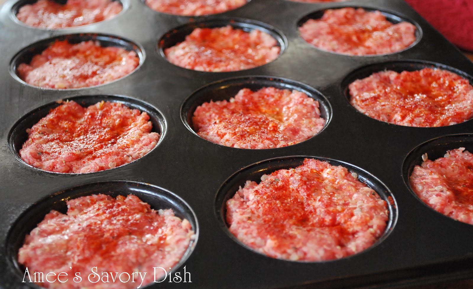 gluten free meatloaf mixture in muffin tins sprinkled with paprika