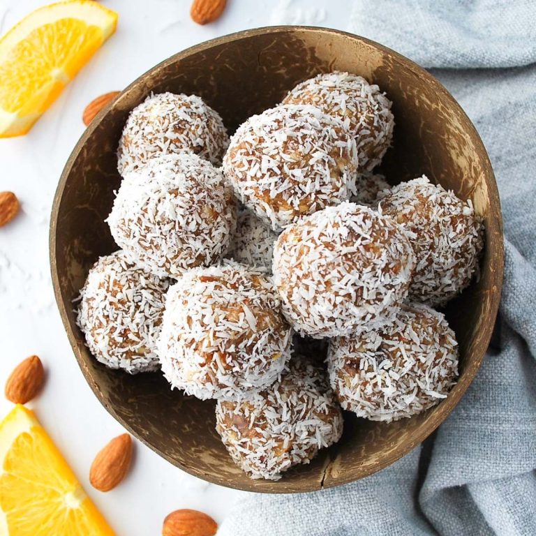 overhead photo of coconut date balls in a coconut shell bowl