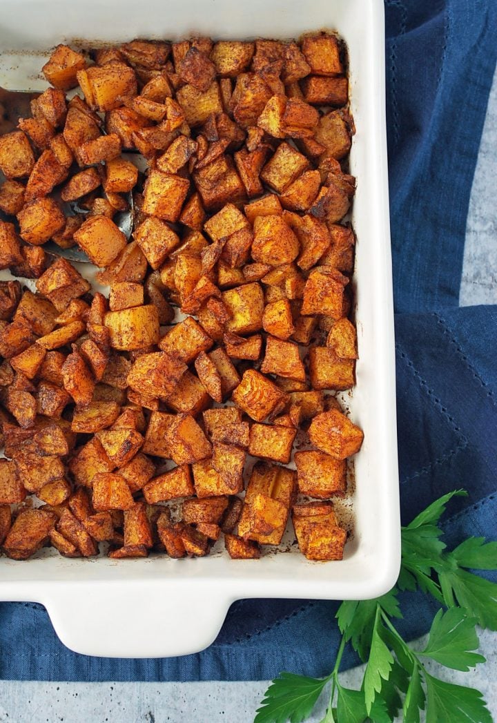 freshly roasted butternut squash in a white dish with blue napkin