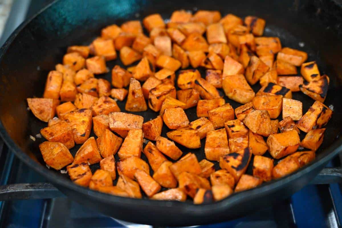 seasoned sweet potatoes in a hot skillet on the stove