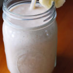 A banana coconut smoothie served in a mason jar glass
