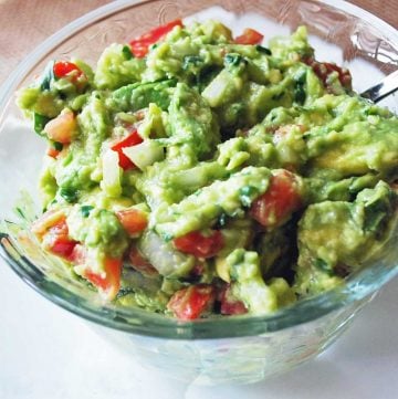 close up photo of guacamole in a clear glass bowl