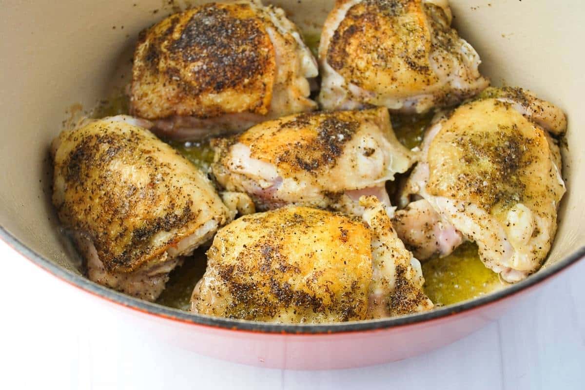 browned chicken thighs in a dutch oven