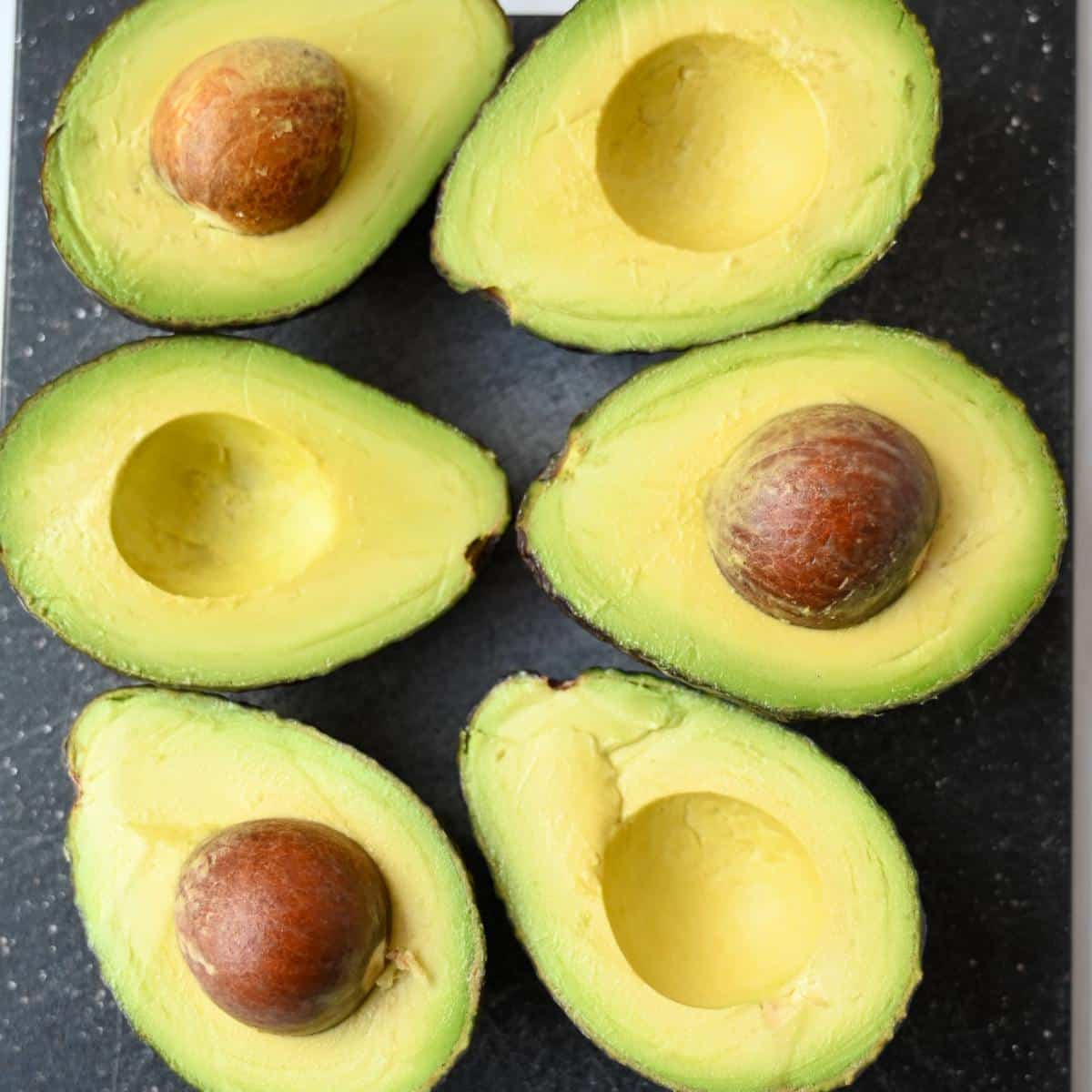 avocados sliced in half on a cutting board