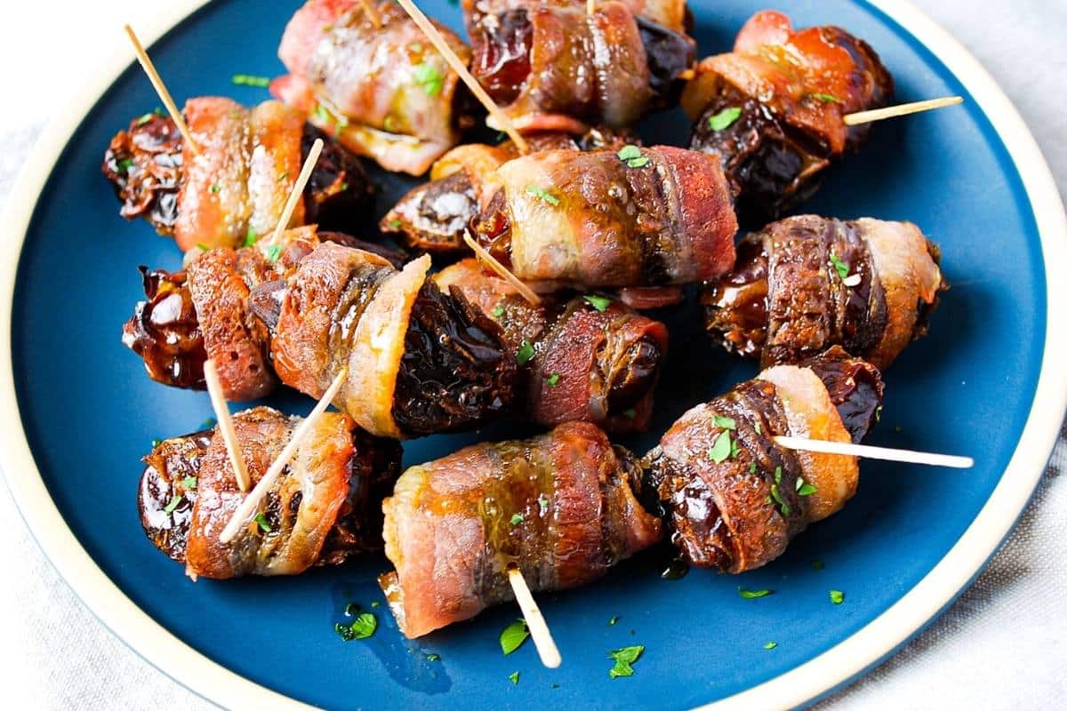 stuffed dates served on a blue plate with toothpicks