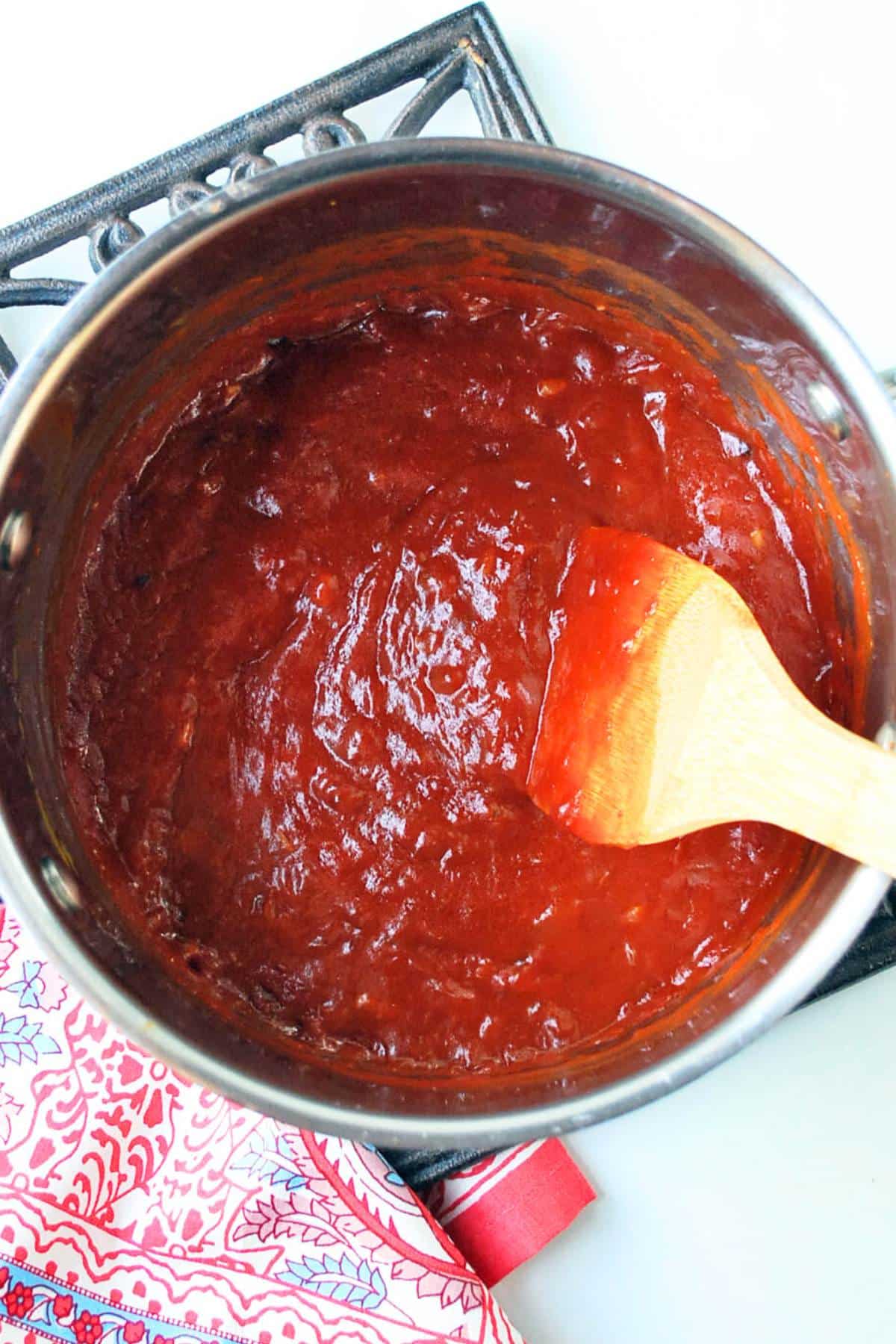 homemade bbq sauce in a saucepan with a spoon